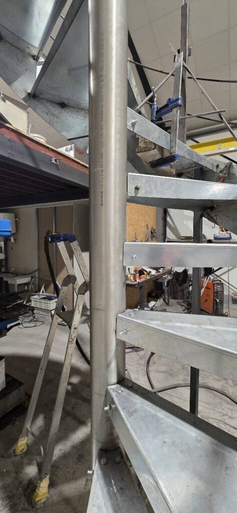 Escalier Colimaçon en Acier : Fabrication et Montage Escalier colimaçon Scominox en acier galvanisé et inox AISI 316L en cours de montage dans un atelier industriel.